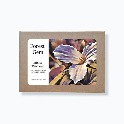Bar of soap with 'Forest Gem' label and floral design on a white background