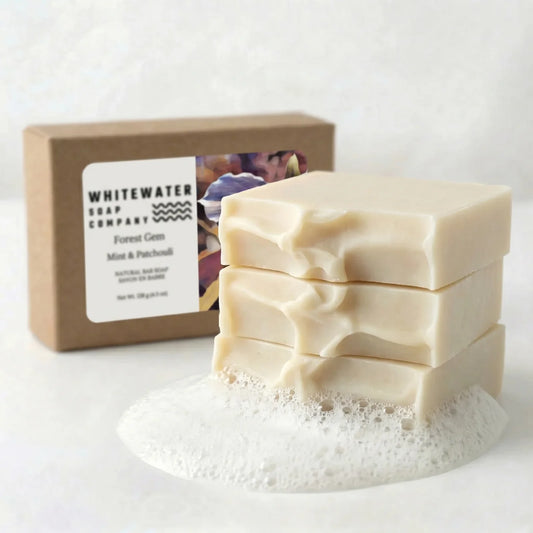 Stack of soap bars with a box labeled 'Whitewater Soap Company' on a white background