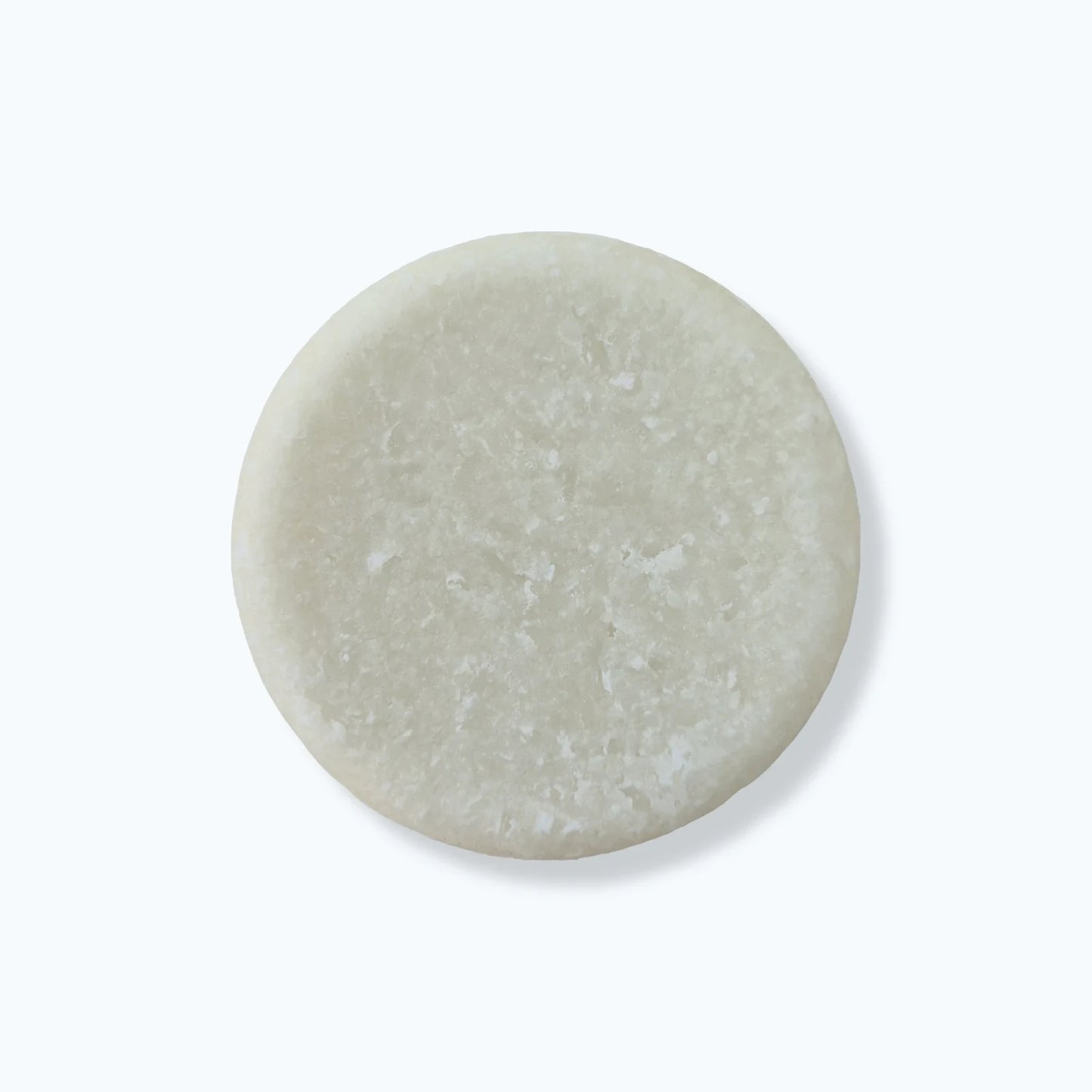 Round solid beard wash bar on a white background