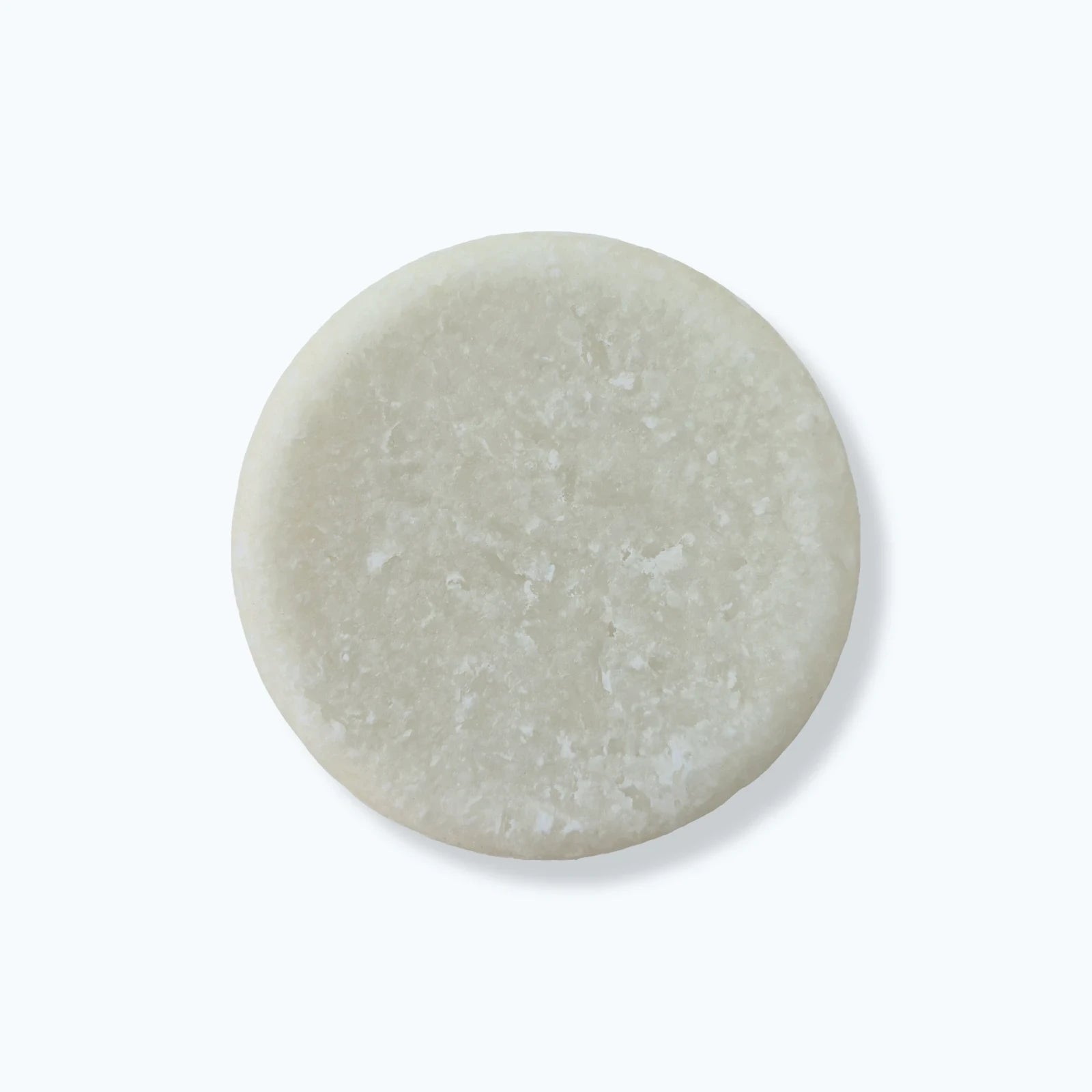 Round solid beard wash bar on a white background