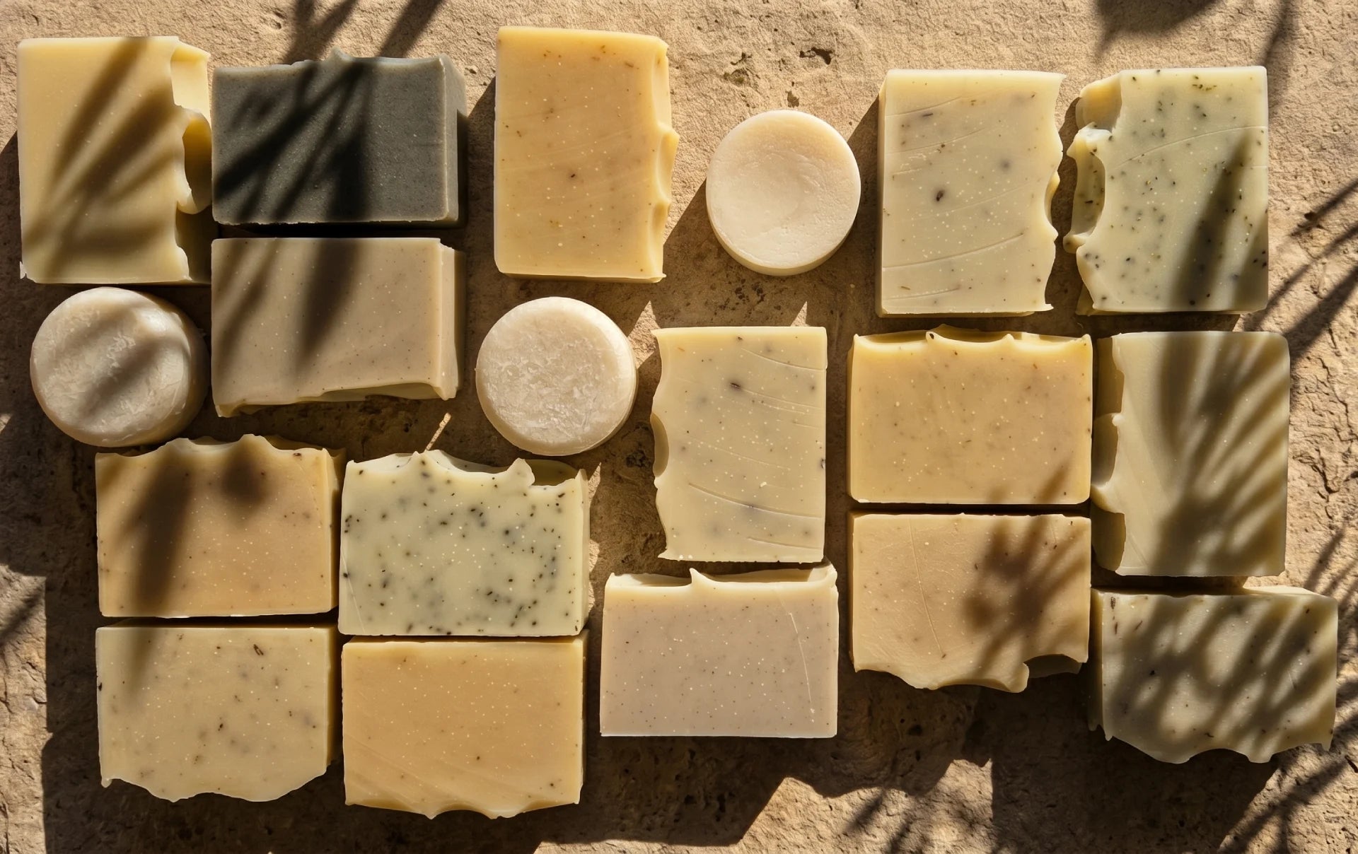 Assorted bars of soap arranged in a pattern on a textured surface