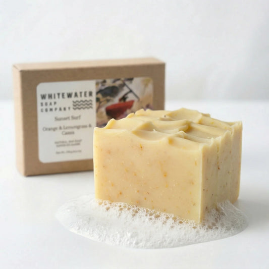 Two bars of soap stacked with a box from Whitewater Soap Company on a white background