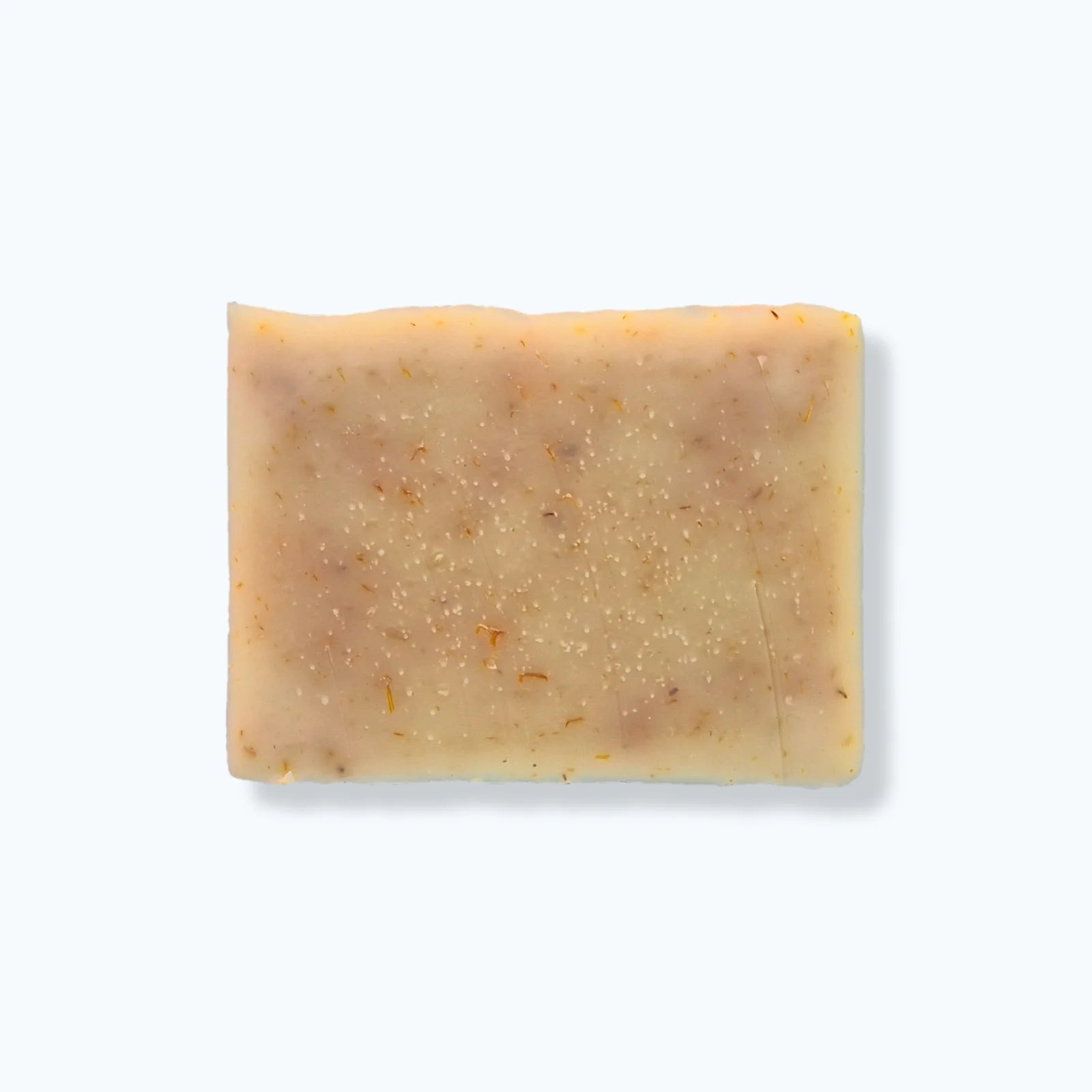 Bar of soap with calendula petals on a white background