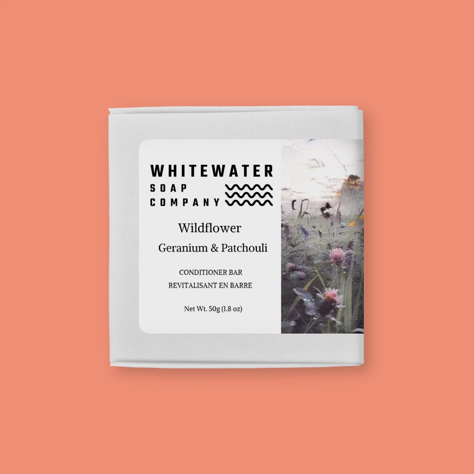 Whitewater Soap Company Wildflower, Geranium & Patchouli conditioner bar packaging on a peach background