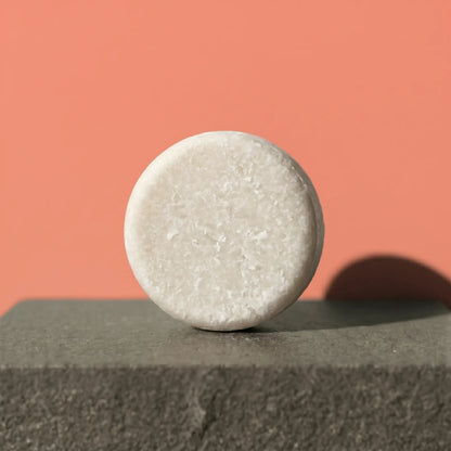 Shampoo bar on a concrete surface with a pinkish-brown background
